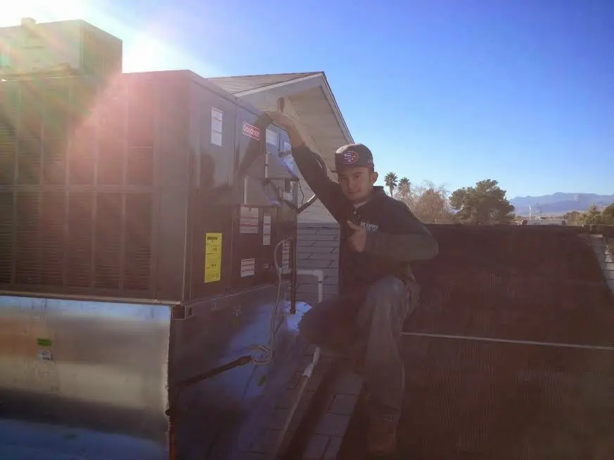 HVAC technician performing Air Duct Cleaning on a rooftop unit in Magnolia